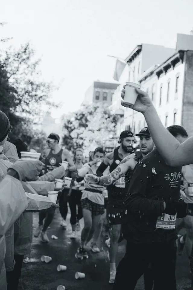 마라토너들이 중간에 종이컵 하나 분량의 물을 마시고 있다.